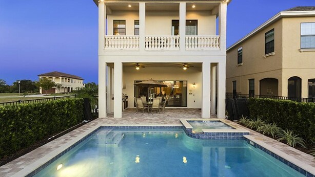 A two-story house with a swimming pool in front.