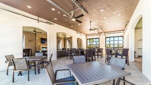 A spacious indoor dining area with multiple tables and chairs, a high ceiling with recessed lighting, and large windows providing natural light. - Beautiful Villa With Private Pool, Close to Disney, Orlando Villa 1835 (Kissimmee)