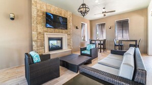 A spacious living area with a stone fireplace, comfortable seating, and a flat-screen TV mounted on the wall. - Beautiful Villa With Private Pool, Close to Disney, Orlando Villa 1835 (Kissimmee)
