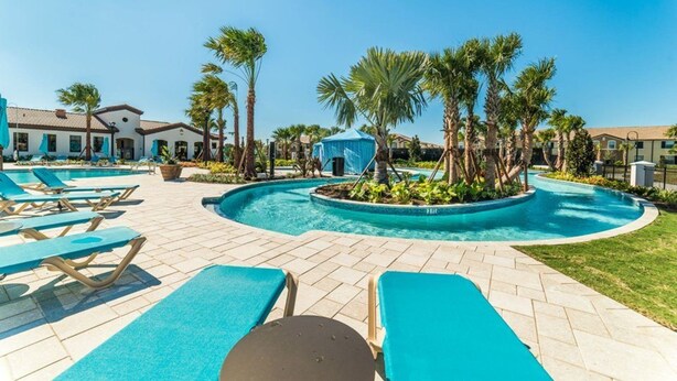 A pool area with lounge chairs, palm trees, and a clear blue sky. - Beautiful Villa With Private Pool, Close to Disney, Orlando Villa 1835 (Kissimmee)