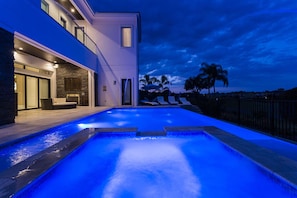Ein modernes Haus mit Swimmingpool im Abenddämmerung.