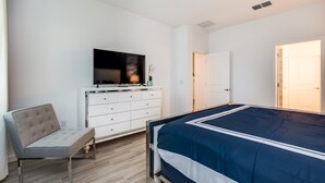 A bedroom with a bed, a TV, a dresser, and a chair. - Beautiful Mansion With Private Pool, Close to Disney, Orlando Mansion 2659 (Kissimmee)