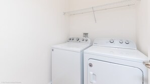 A laundry room with two white front-loading washers and a metal drying rack on the wall. - Beautiful Mansion With Private Pool, Close to Disney, Orlando Mansion 2659 (Kissimmee)