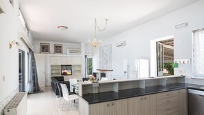 A modern kitchen with a central island, built-in cabinets, and a dining area with chairs.