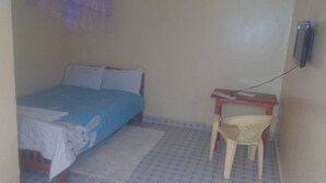 Una habitación pequeña con una cama, un escritorio y una silla.