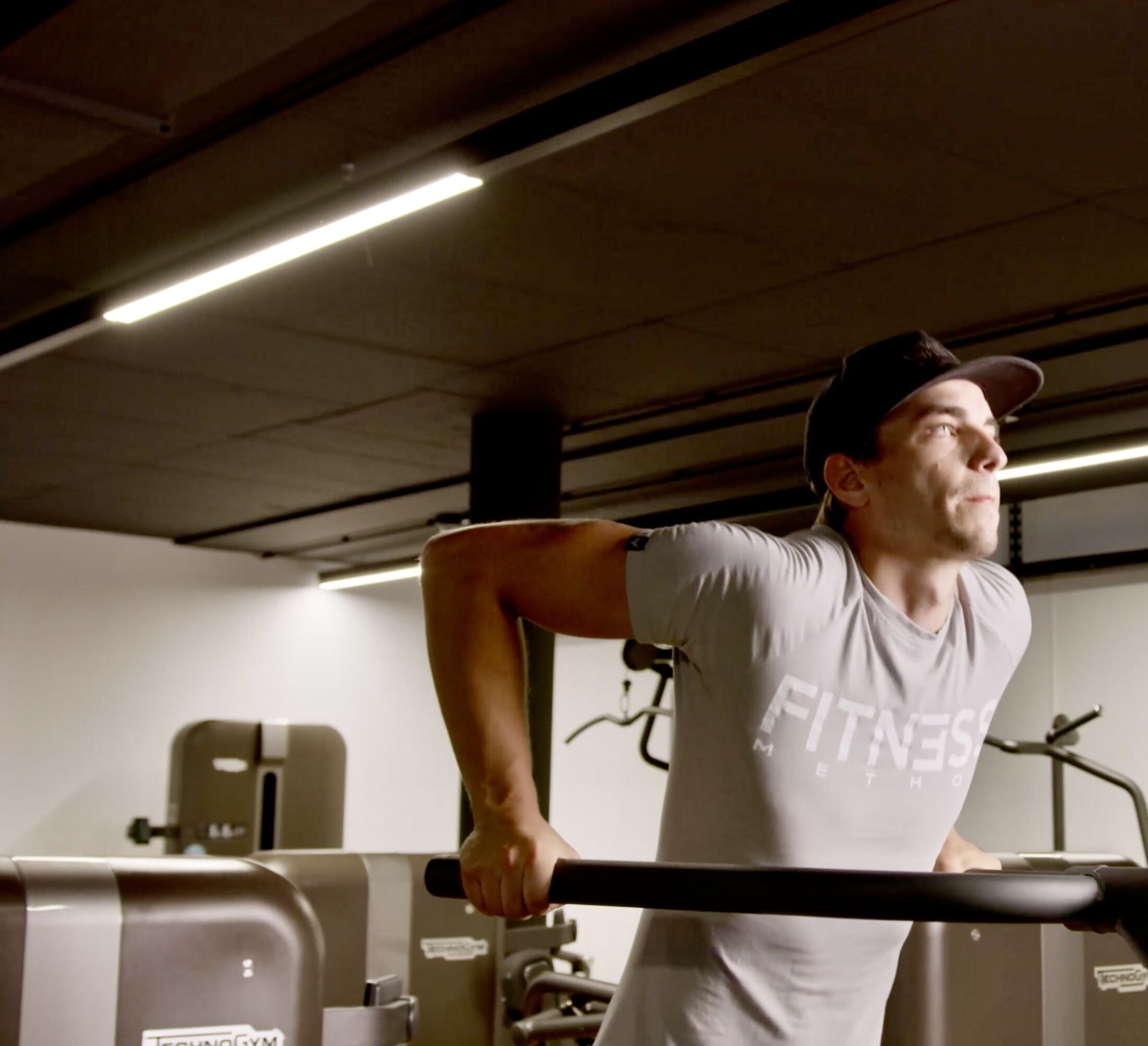 Une salle de sport équipée de matériel d’exercice, notamment une barre d’haltères et un tapis de course.