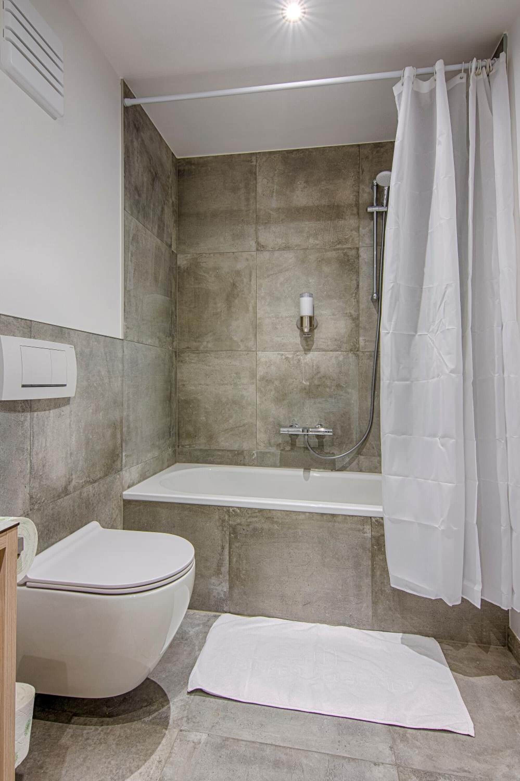 A bathroom with a toilet, a shower, and a bathtub.