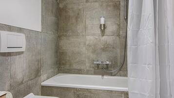 A bathroom with a toilet, a shower, and a bathtub.