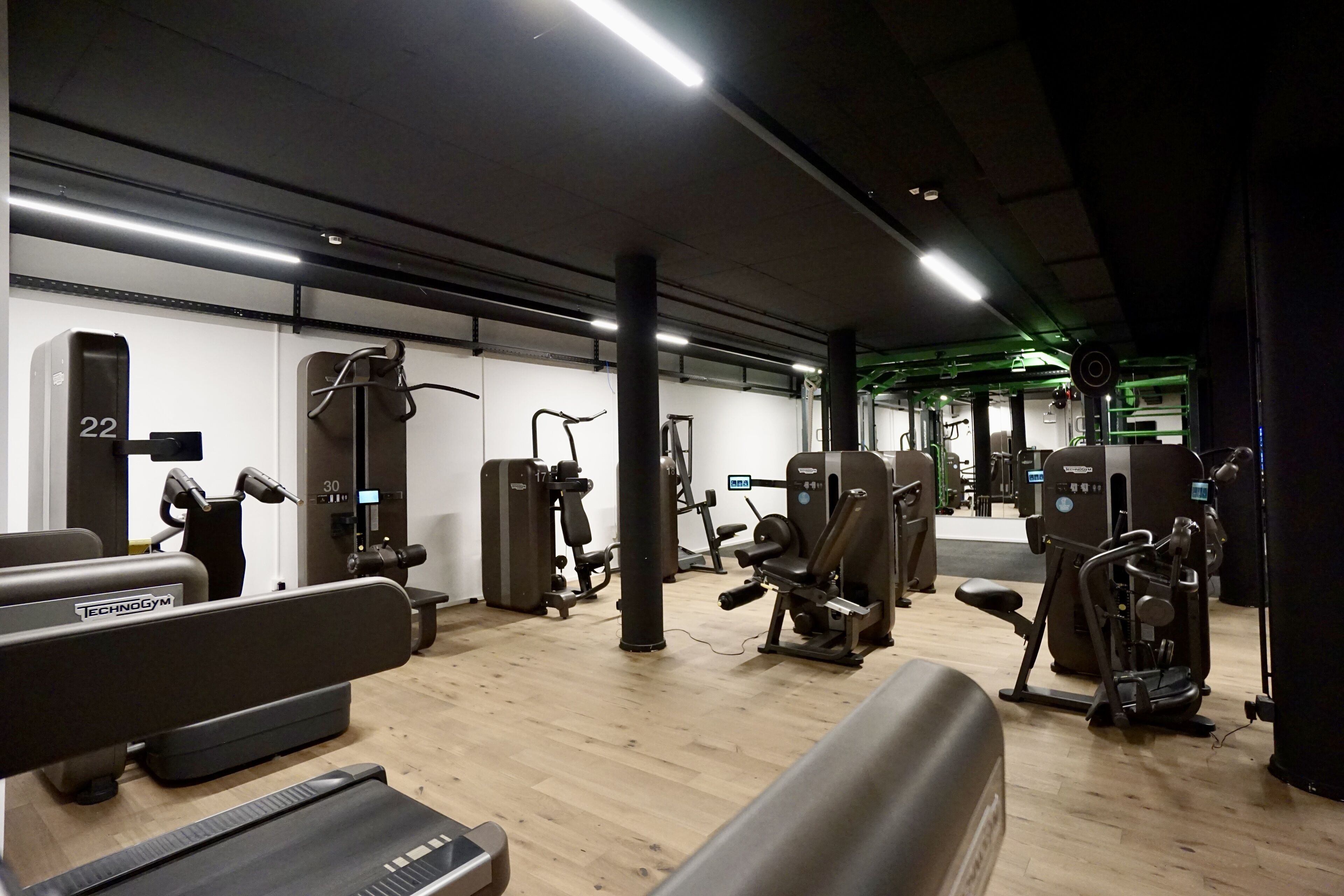 A gym with various exercise machines, a treadmill, and a weight bench.