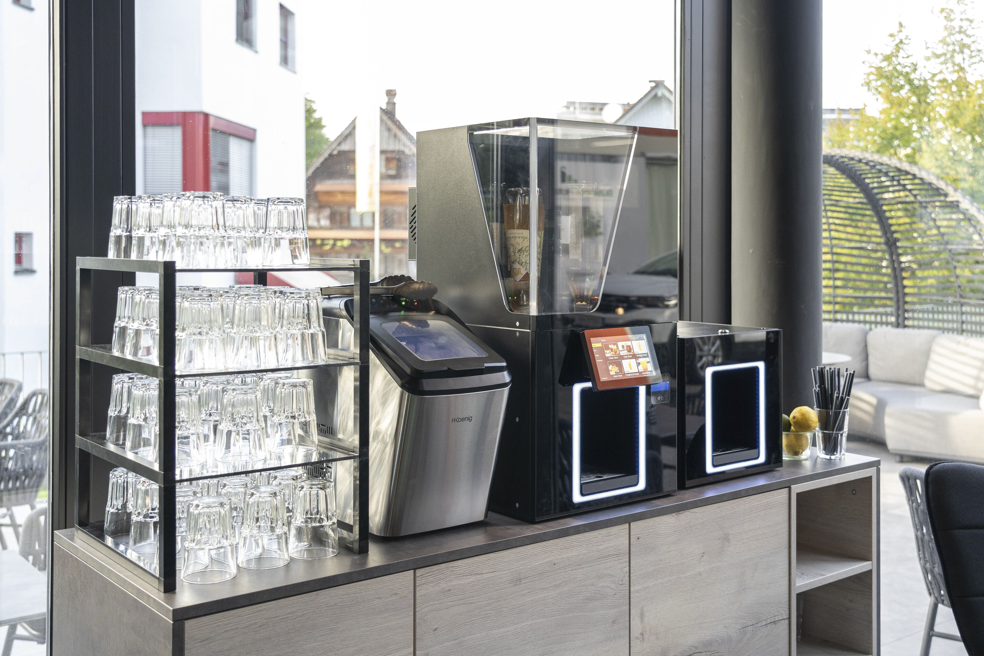 A bar area with a glass display case, a coffee machine, and a coffee dispenser.