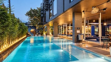 Een binnenzwembad met een glijbaan, zitgedeeltes en een modern architectonisch ontwerp.