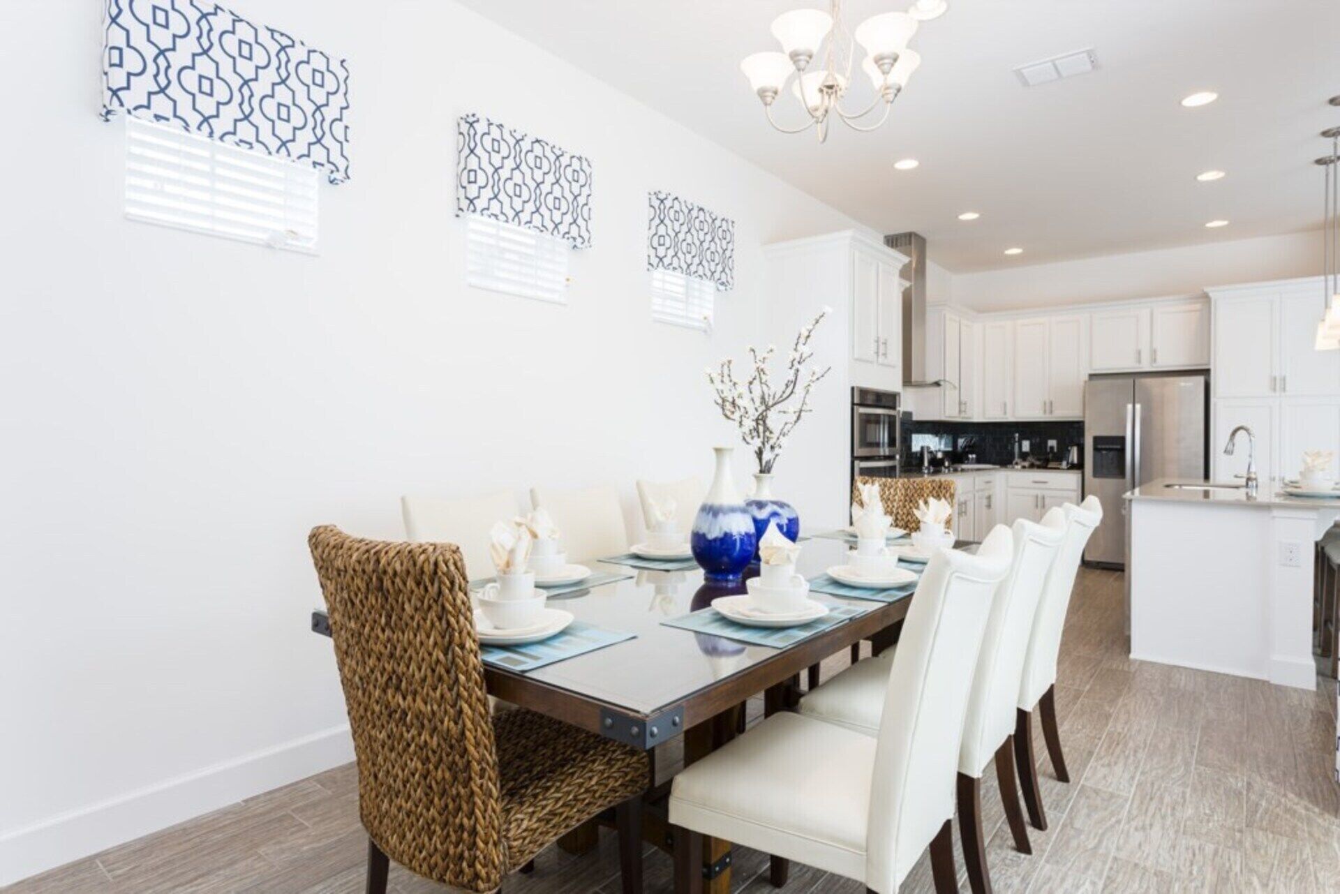 A modern dining area with a wooden table, white chairs, and decorative vases.