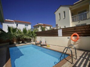 A swimming pool with a wooden deck, a lifebuoy, and a chair. - Beautiful Villa With Private Pool, Protaras Villa 1020 (Paralimni)