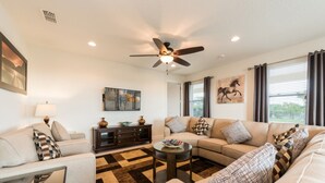 A living room with a sofa set, a coffee table, a side table, and a ceiling fan.