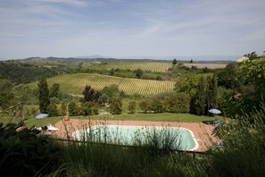 A pool with a surrounding patio area, a grassy field, and distant hills. - Room in B&B - A Little Place in Tuscany Where to Relax (Montaione)