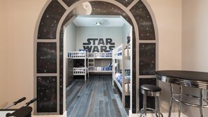Una stanza a tema Star Wars con letti a castello, un angolo bar e una parete a tema galattico.