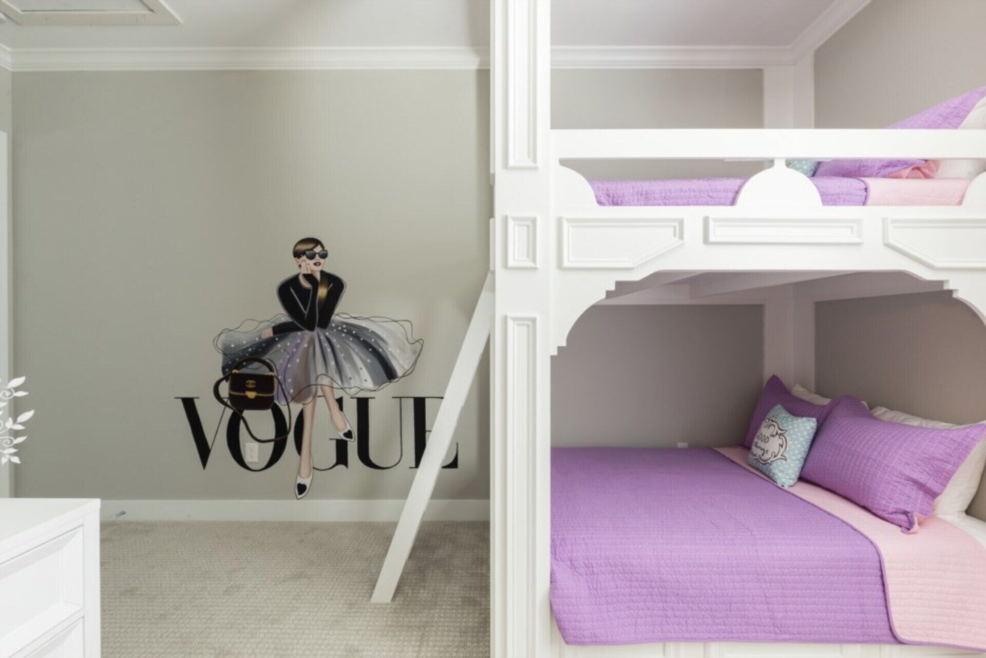 A room with a bunk bed, a wall with 'VOGUE' written on it, and a mannequin dressed in a black outfit.
