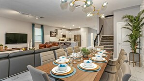 Un espace de restauration moderne avec une longue table en bois, dressée pour six personnes, et entouré de sièges confortables.