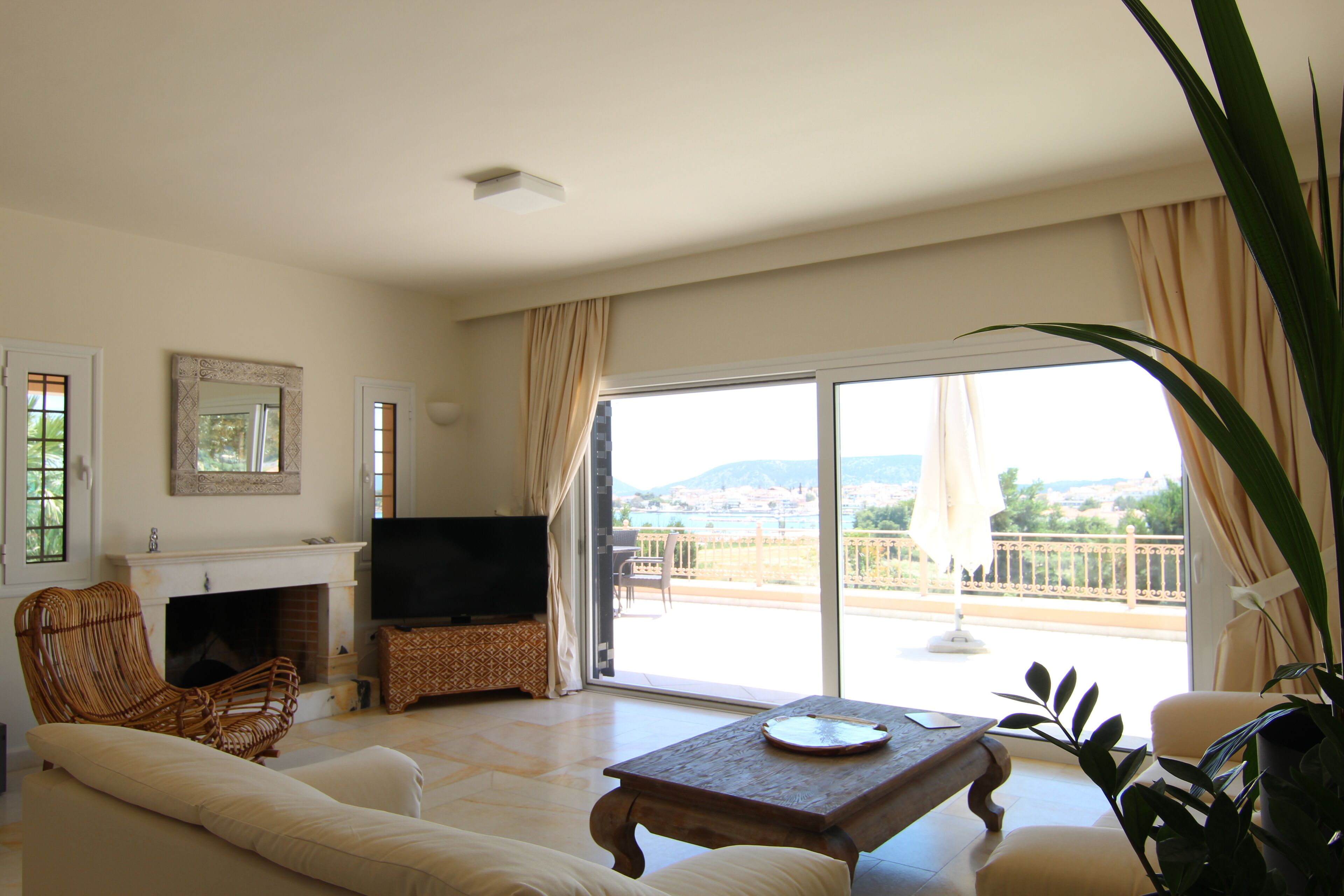 Un salon avec une cheminée, un téléviseur et un balcon offrant une vue agréable.