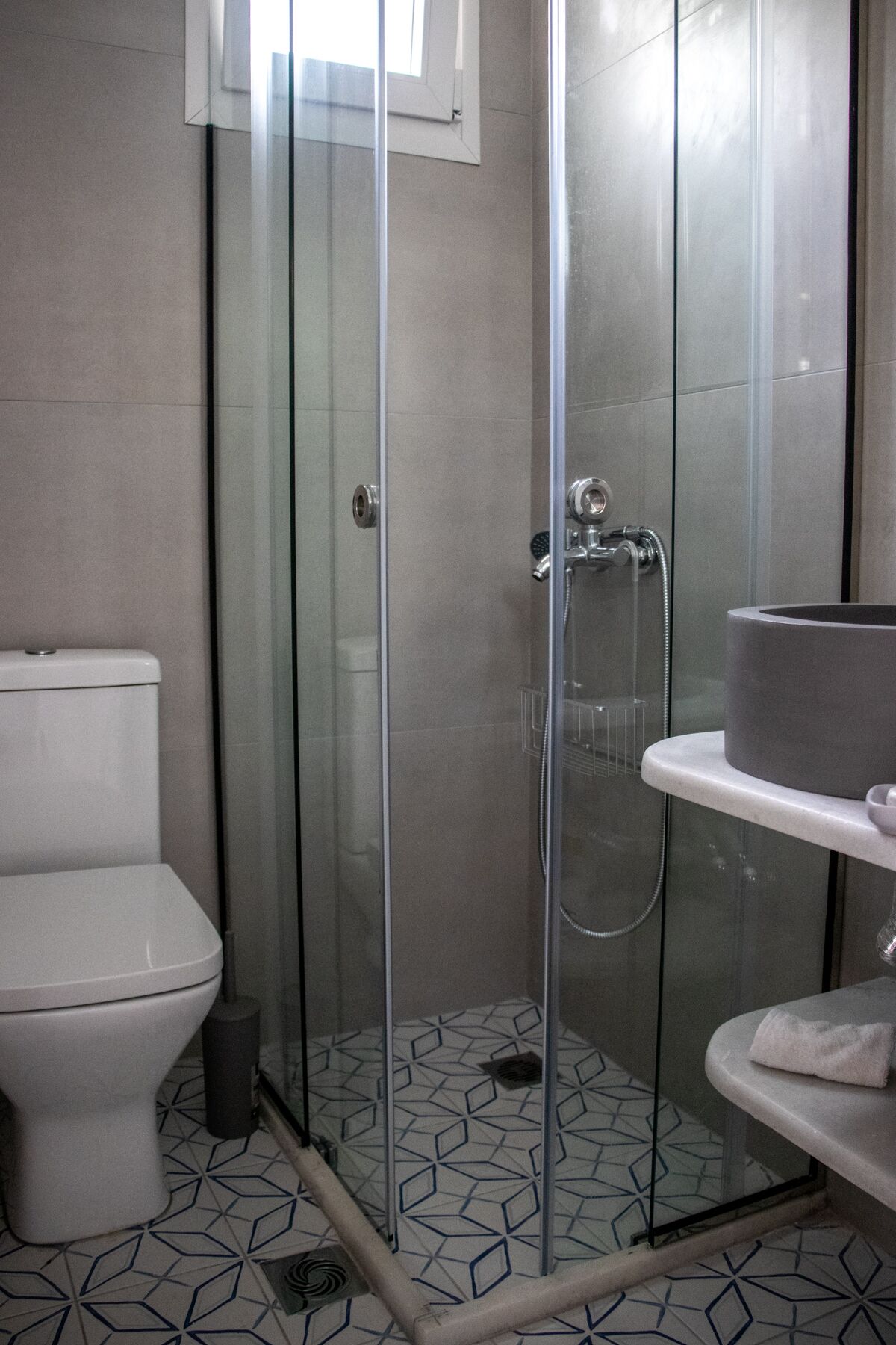 Une salle de bain avec une douche à parois de verre, des toilettes et un lavabo avec une serviette.