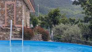 Uma piscina com um edifício de pedra ao fundo.