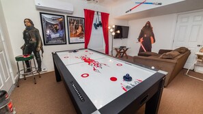 A room with a foosball table, a sofa, a TV, and Star Wars posters. - Villa Close to Disney, Orlando Villa 3264 (Kissimmee)
