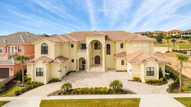 A large, single-story house with a tiled roof, a central entrance, and a landscaped front yard. - Beautiful Mansion With Private Pool, Close to Disney, Orlando Mansion 1574 (Kissimmee)