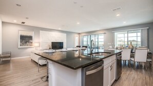 A spacious kitchen with a large island, modern appliances, and a dining area with a view. - Beautiful Villa With Private Pool, Close to Disney, Orlando Villa 2657 (Kissimmee)