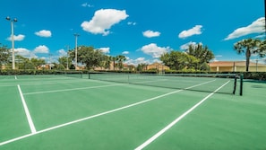 A tennis court with a net, surrounded by trees and buildings. - Villa Close to Disney, Orlando Villa 3261 (Kissimmee)