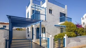 A two-story building with a white exterior and blue accents, including balconies and railings. - Beautiful Villa With Private Pool, Pernera Villa 1004 (Paralimni)