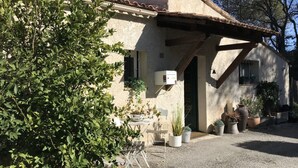 A rustic house with a tiled roof, a small porch with potted plants, and a gravel driveway. - VILLA WITH POOL, PANORAMIC VIEW, 5 MINUTES WALK FROM THE VILLAGE (Lorgues)