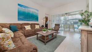 Un salon moderne avec un canapé marron, une table basse et une vue sur un balcon.