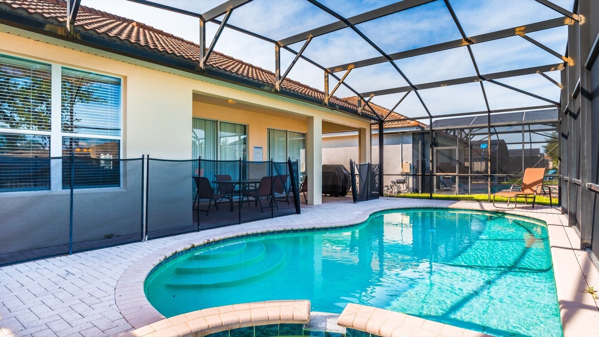 Piscina interna com teto de vidro, rodeada por espreguiçadeiras e uma área de estar ao ar livre.