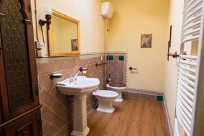 Un bagno con un lavandino su piedistallo, un WC e una doccia.