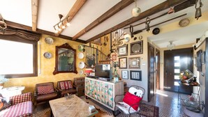 A cozy living room with a wooden ceiling, a sofa, a coffee table, and a cabinet with decorative plates. - Rosa: A special holiday home in L´Escala (L'Escala)