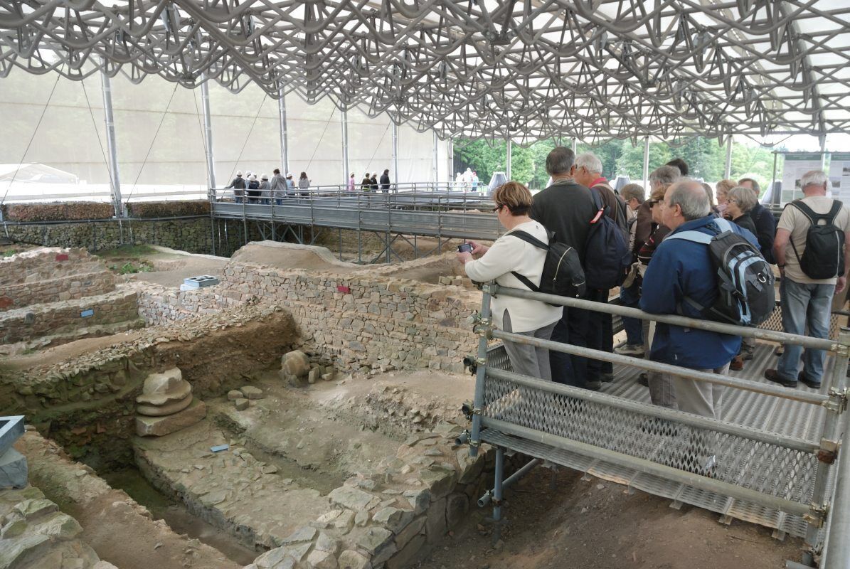 An archaeological site with visitors observing ancient ruins.