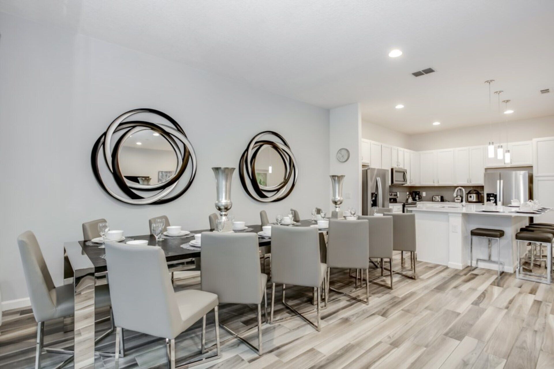 A modern kitchen with white cabinets, a central island, and stainless steel appliances.