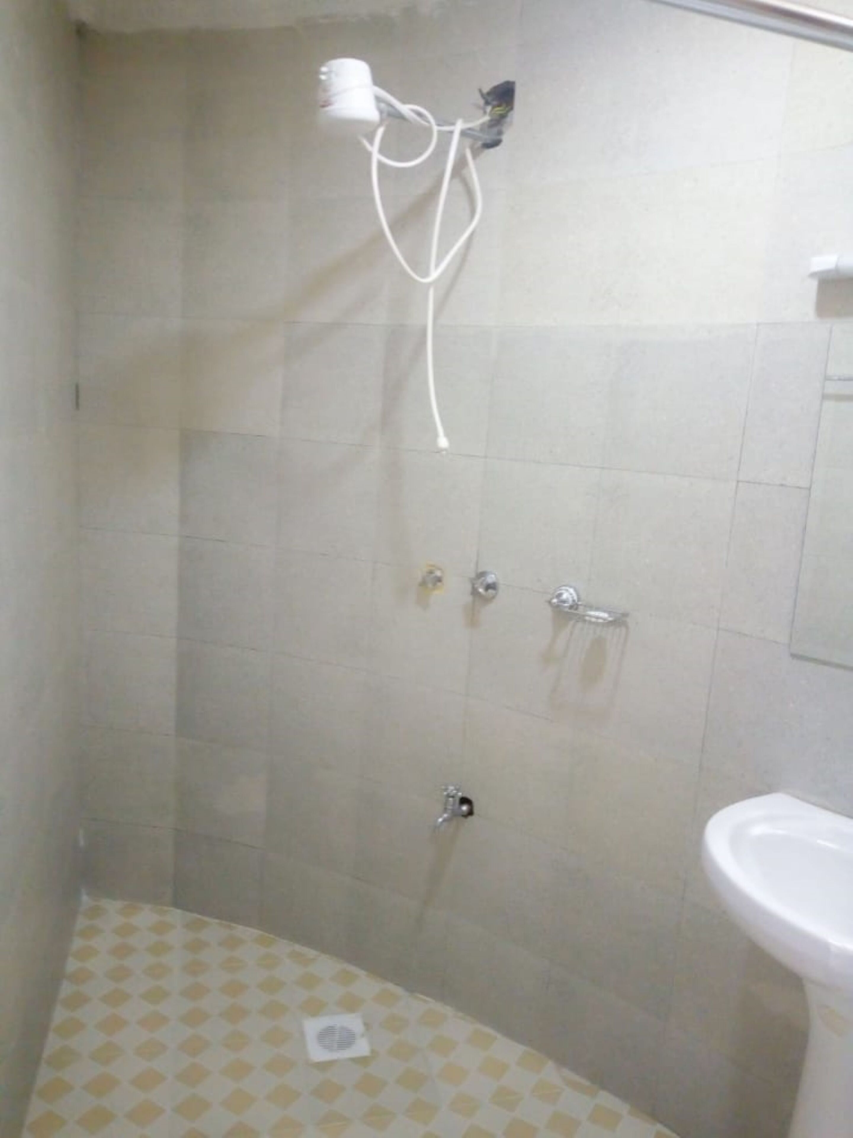 A bathroom with a shower, a sink, and a toilet.