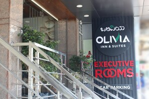 The entrance to Olivia Inn & Suites with a sign for Executive Rooms and a mention of car parking.