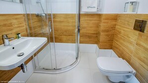 A bathroom with a glass-enclosed shower, a white sink, and a toilet. - Apartament z widokiem na morze - Nadmorski Luksus Apartamenty (Ustronie Morskie)