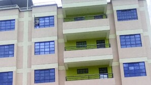 A multi-story building with a symmetrical facade, featuring balconies on each floor. - MT Ararat Hotel (Nakuru)
