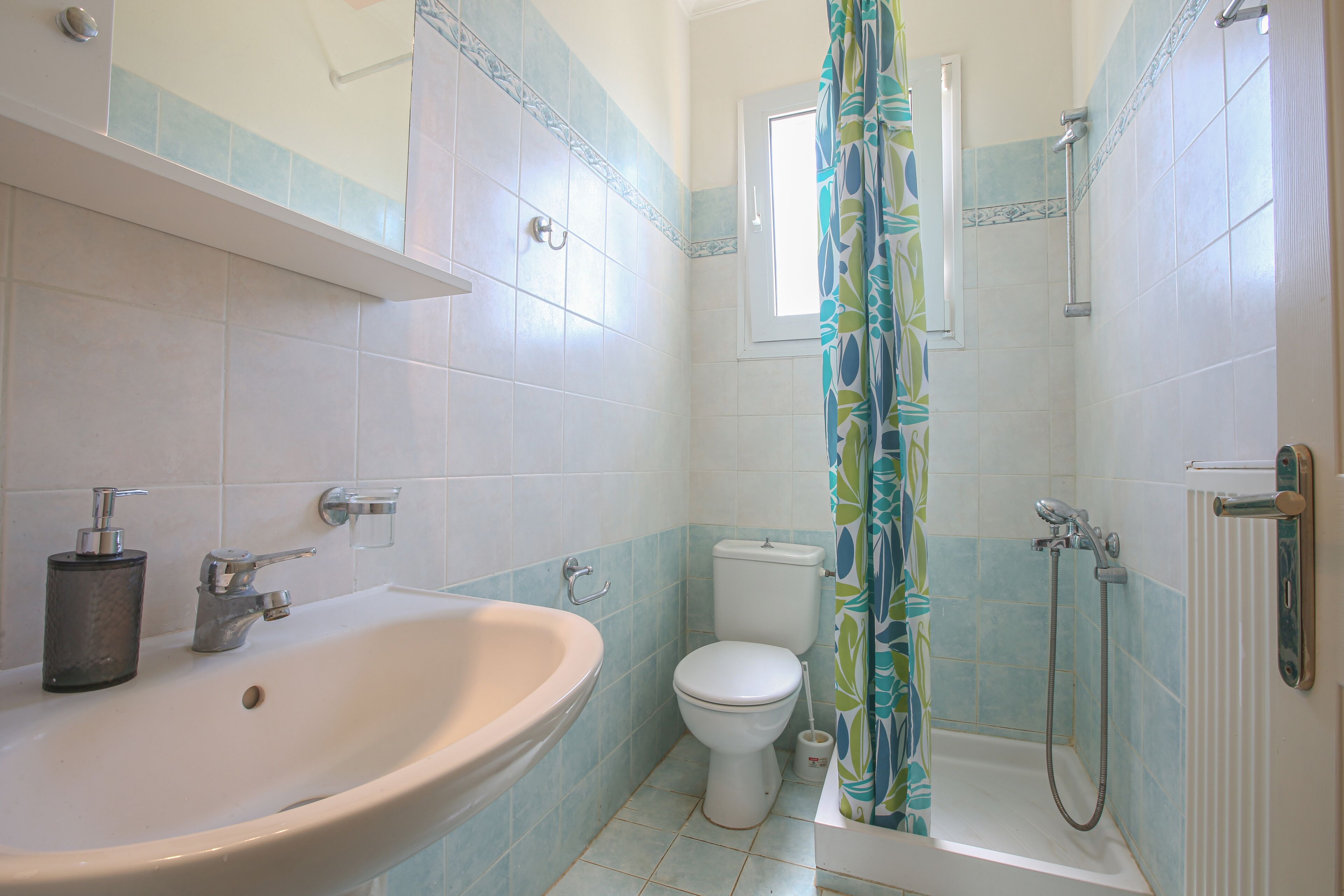 A bathroom with a sink, toilet, and shower.