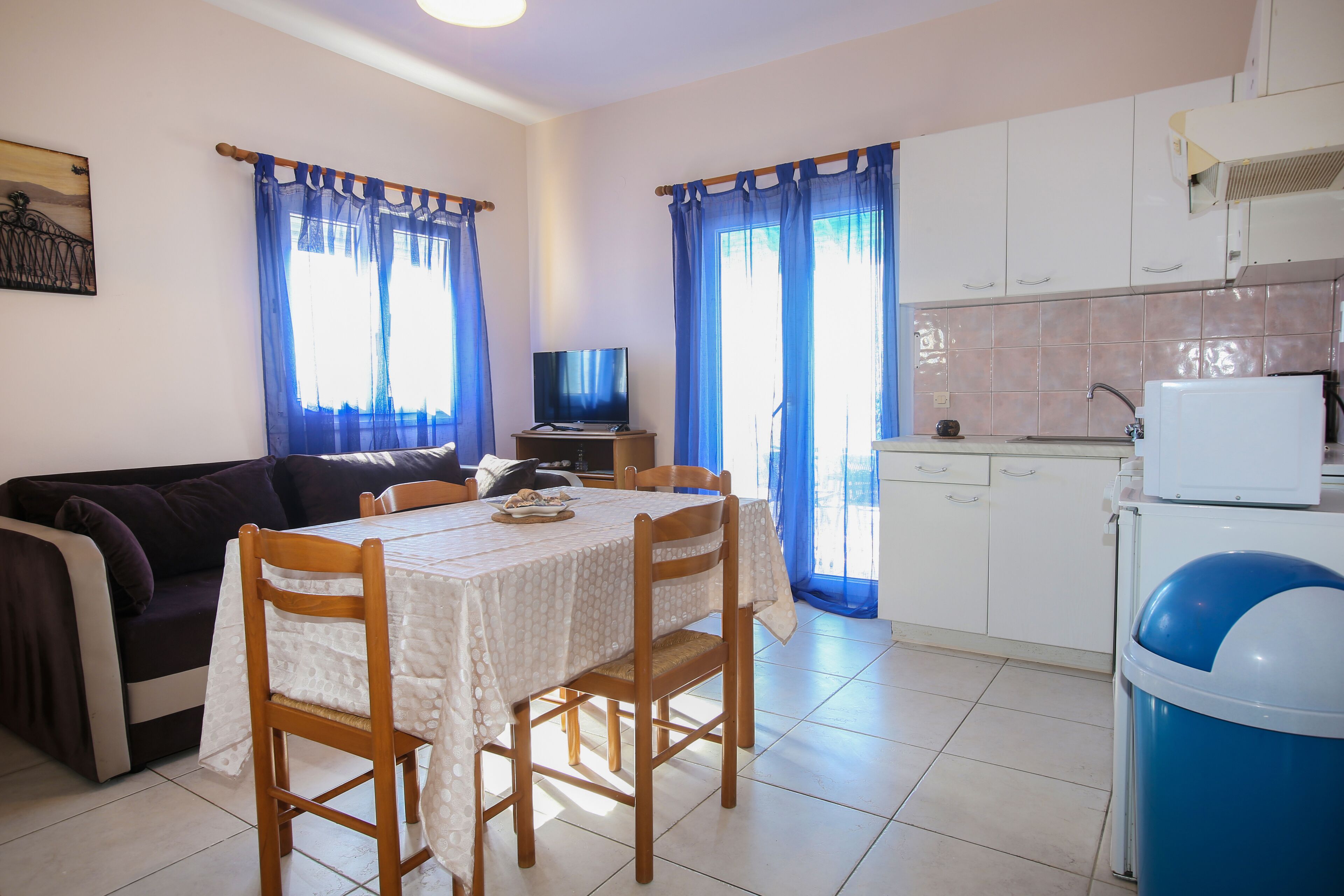A compact living space with a dining area, kitchenette, and a sofa.