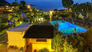 A pool area with lounge chairs and a small building, surrounded by greenery and overlooking a body of water. - Room in B&B - Ischia, 1 Relaxing Doubles Hotel Imperamare (Forio)