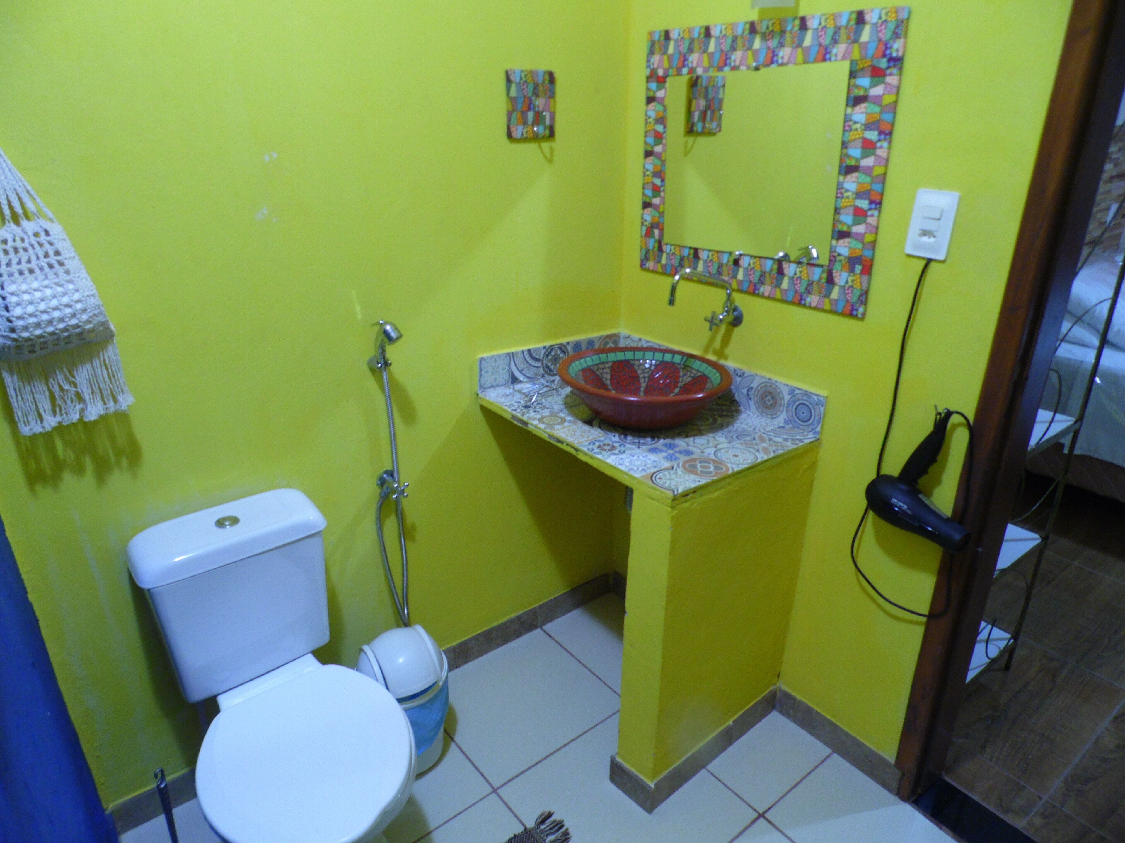 Ein kleines Badezimmer mit Toilette, Waschbecken und Dusche.