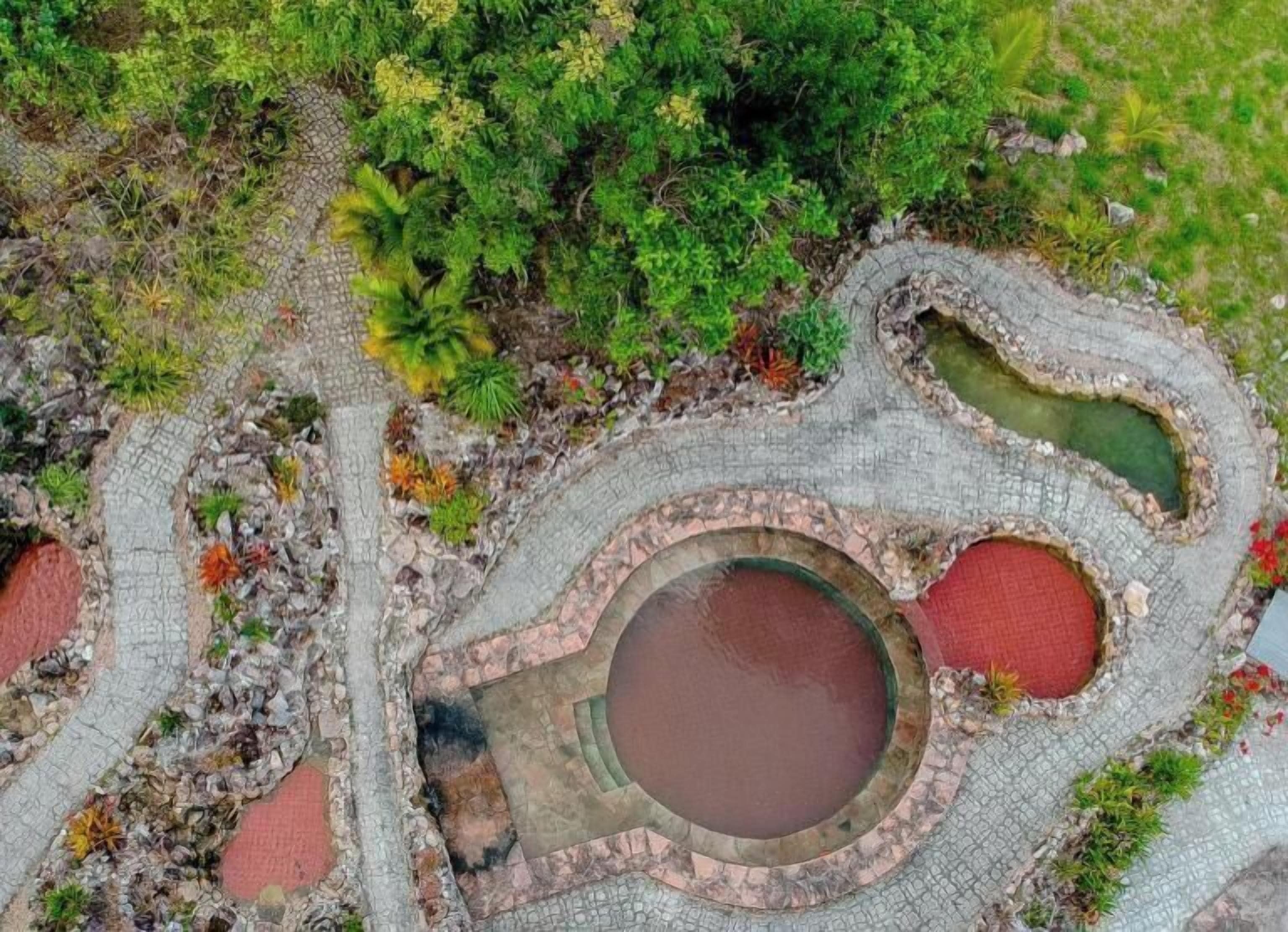 An aerial view of a landscaped area with multiple ponds and stone pathways.