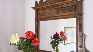 A wooden dresser with a mirror above it, reflecting a vase with flowers and a small potted plant. - Apartment le Scalette a Relaxing Oasis Near Florence (Vicchio)