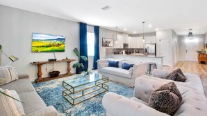 Un salon moderne avec un canapé, une table basse et un tableau accroché au mur.