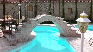 A swimming pool with a stone bridge, steps, and a lamp post. - Historical Residence il Biribino 27 People (Città di Castello)