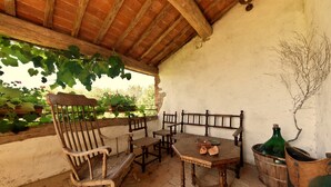 A rustic outdoor seating area with wooden furniture and a brick floor. - la Casa - Agriturismo With Pool Between Siena and Grosseto (Civitella Paganico)